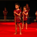 kinderen die dansen tijdens voorstelling, verkleed als gladiatoren