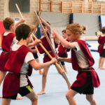 kinderen die een gladiatorengevecht naspelen
